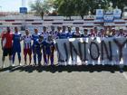 Jugadores de ambos equipos posan con una pancarta en un amistoso celebrado la temporada recién acabada