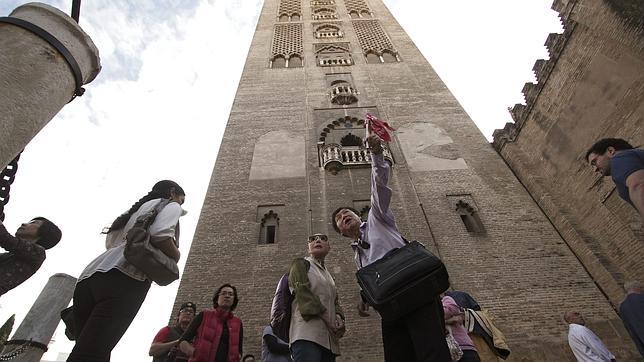Turistas a los pies de la Giralda de Sevilla