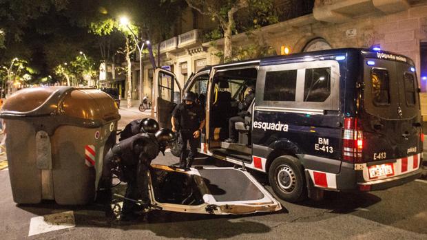 Dos Mossos d'Esquadra recogen la puerta de su furgón durante los altercados del 1 de octubre