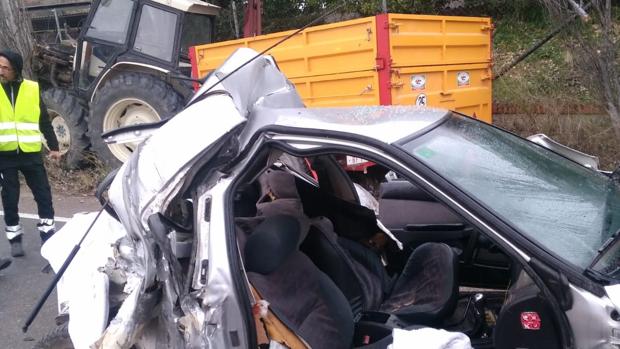 Estado en el que quedó el vehículo que chocó con el tractor, al fondo