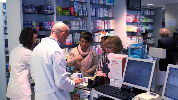 Farmacéuticos atienden a clientes en una farmacia