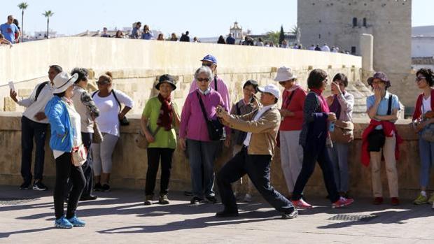 Un grupo de turistas se fotografían en el Puente Romano