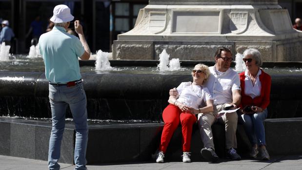Turistas se fotografían en la fuente de Las Tendillas