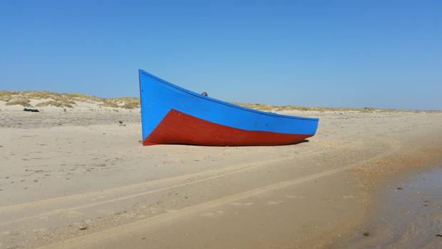 La patera encallada en la costa de Matalascañas a mediodía de este domingo