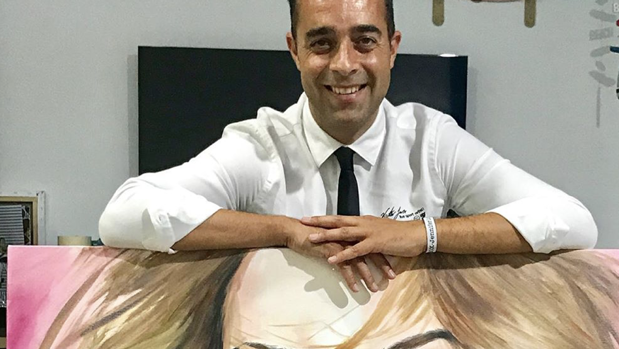 Alejandro Jeréz apoyado en el retrato de Jennifer López