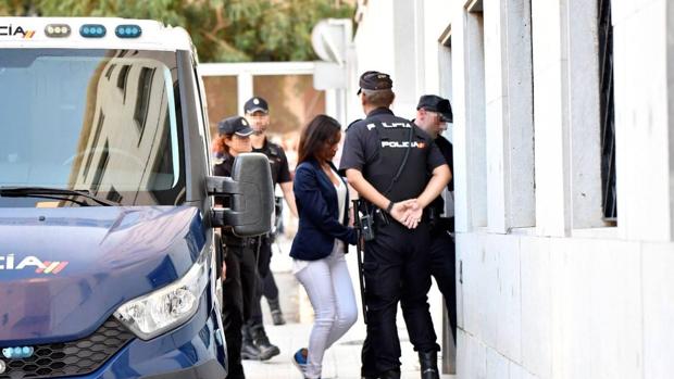 Ana Julia Quezada, custodiada por varios policías, entra en los juzgados