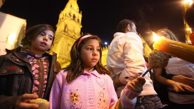 Dos niñas recogen cera en la Semana Santa de Córdoba