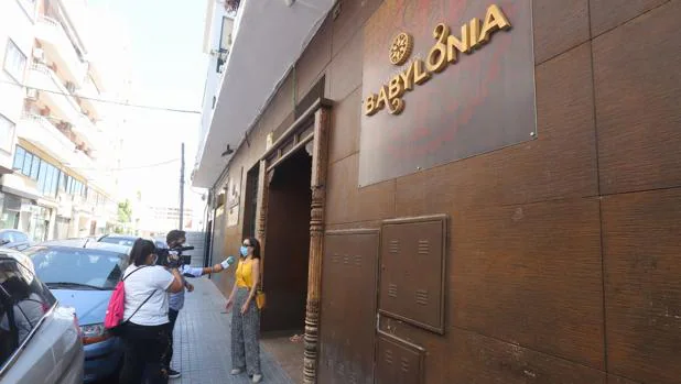 Un reportero entrevista a una mujer en la puerta del a discoteca Babylonia de Córdoba