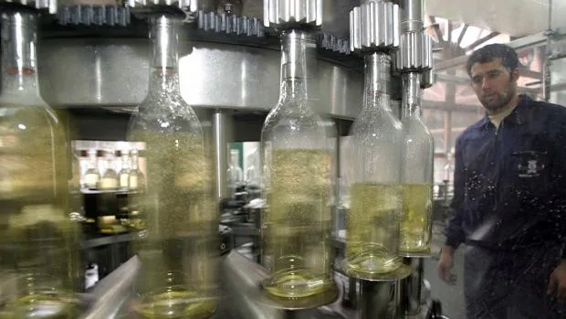 Un operario en una planta de embotellado de vinos