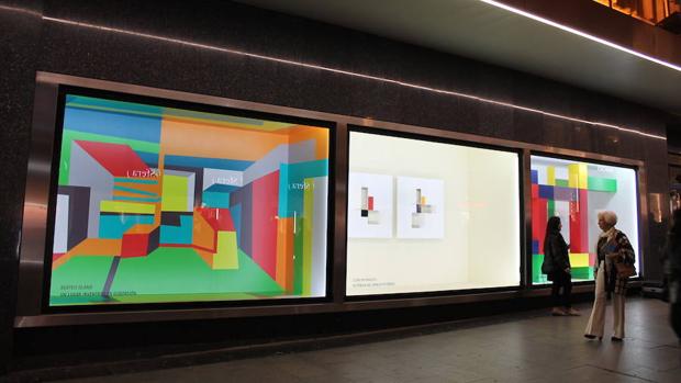 Viandantes pasan por delante de los escaparates de El Corte Inglés de Preciados