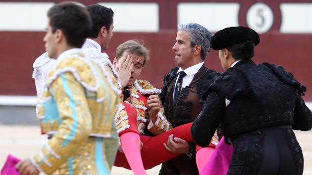 Javier Cortés se tapa el ojo dañado mientras es trasladado por las cuadrillas a la enfermería