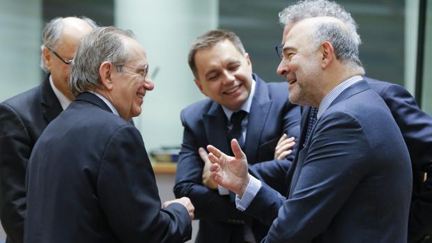 El comisario europeo de Asuntos Económicos y Financieros, Pierre Moscovici (d) saluda al ministro de Finanzas italiano, Pier Carlo Padoan (i) durante la reunión de ministros de Economía y Finanzas de la eurozona (Eurogrupo) en Bruselas