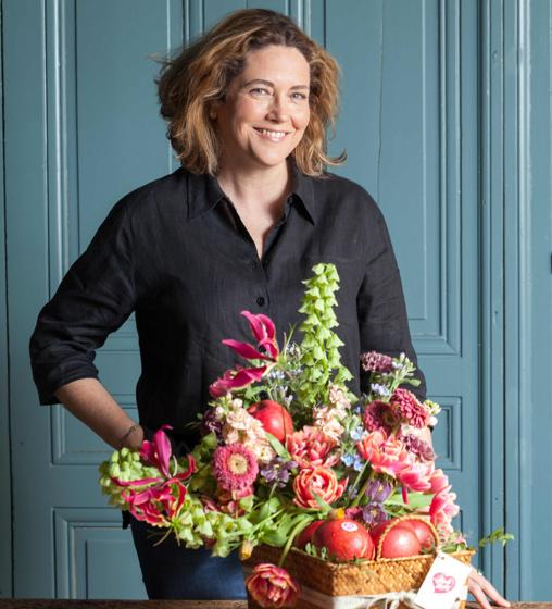 Sally Hambleton posa con el centro floral que ha creado con la manzana Pink Lady como inspiración