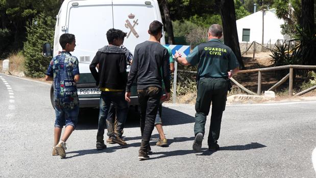 Un guardia civil acompaña a un grupo de menores extranjeros que se había escapado en Barbate