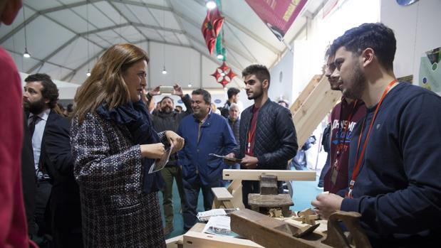 La consejera de Educación en funciones de la Junta, Sonia Gaya, atiende las explicaciones de varios estudiantes