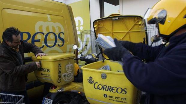 Dos carteros guardan la correspondencia antes del reparto en una imagen de archivo