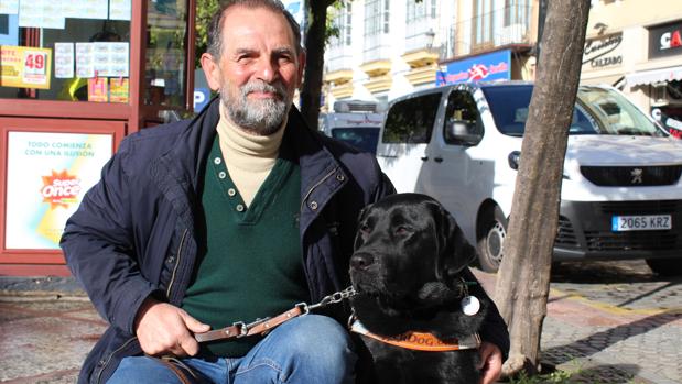 El utrerano Ricardo Fernández junto a su perro labrador que le sirve de guía