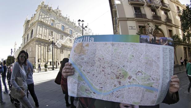 Dos turistas consultan un mapa de Sevilla en el Casco Histórico