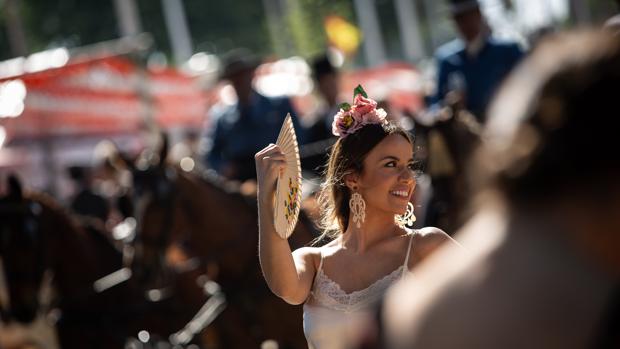 Una mujer se abanica en el Real de la Feria