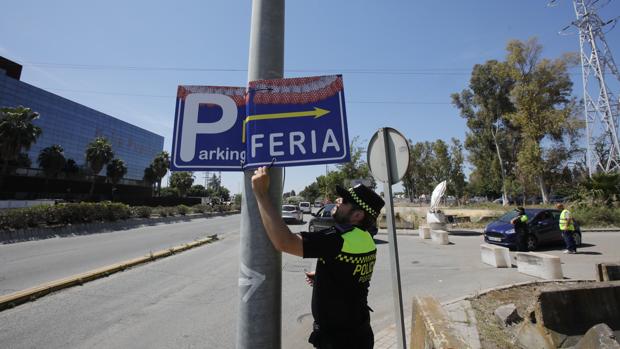 Un agente retira un cartel que dirigía a los conductores a uno de los aparcamientos ilegales