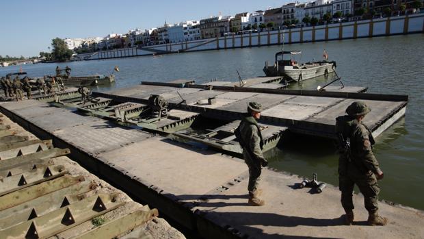 Montaje en el río Guadalquivir del puente flotante que formará parte de la exhibición de este jueves