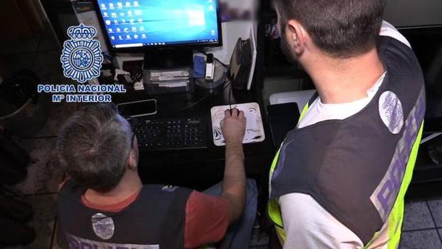 Imagen de archivo de dos agentes de Policía revisando el material intervenido en una operación